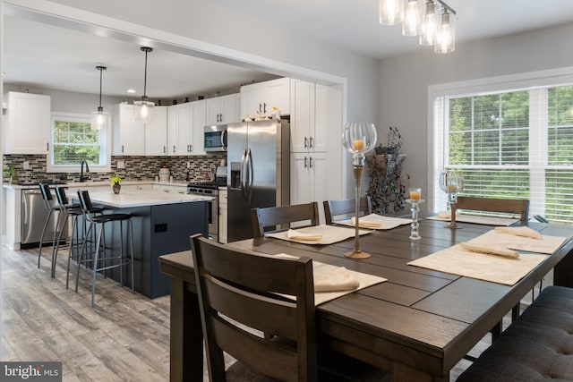 dining area with light hardwood / wood-style flooring, sink, and a wealth of natural light