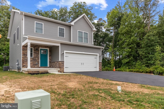 view of front facade with a garage, cooling unit, and a front yard