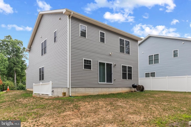 rear view of property featuring a lawn