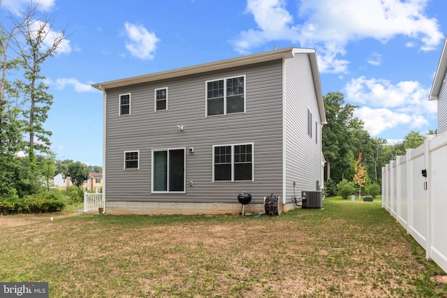 back of property featuring central air condition unit and a lawn