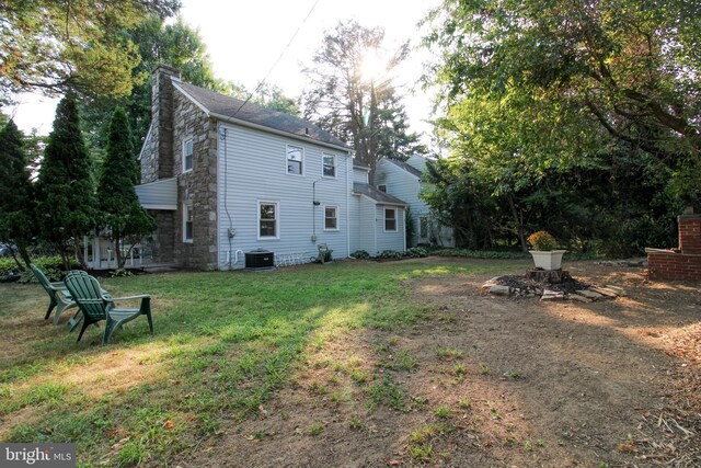 back of property featuring a lawn and central AC unit