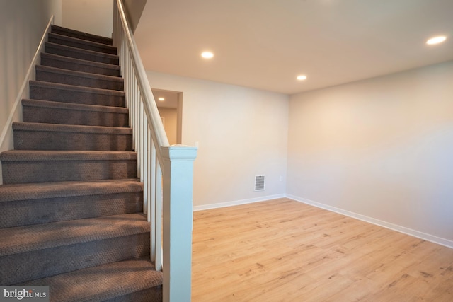 stairs featuring hardwood / wood-style floors