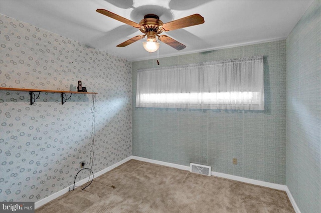 spare room featuring carpet, a wealth of natural light, and ceiling fan