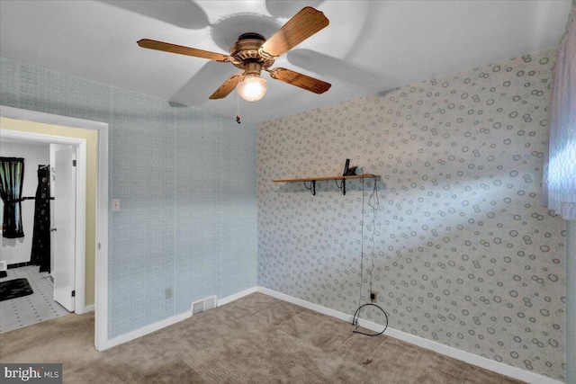 carpeted spare room with ceiling fan