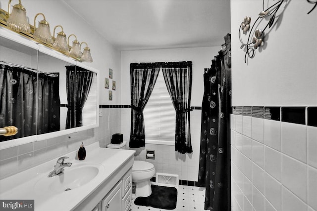 bathroom featuring tile walls, vanity, and toilet