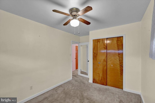 unfurnished bedroom with light carpet, a closet, and ceiling fan