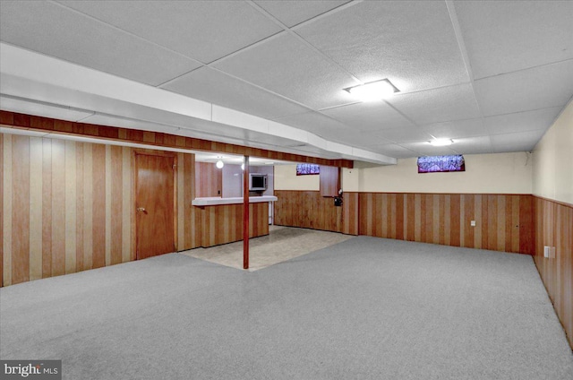 basement featuring carpet floors and a paneled ceiling