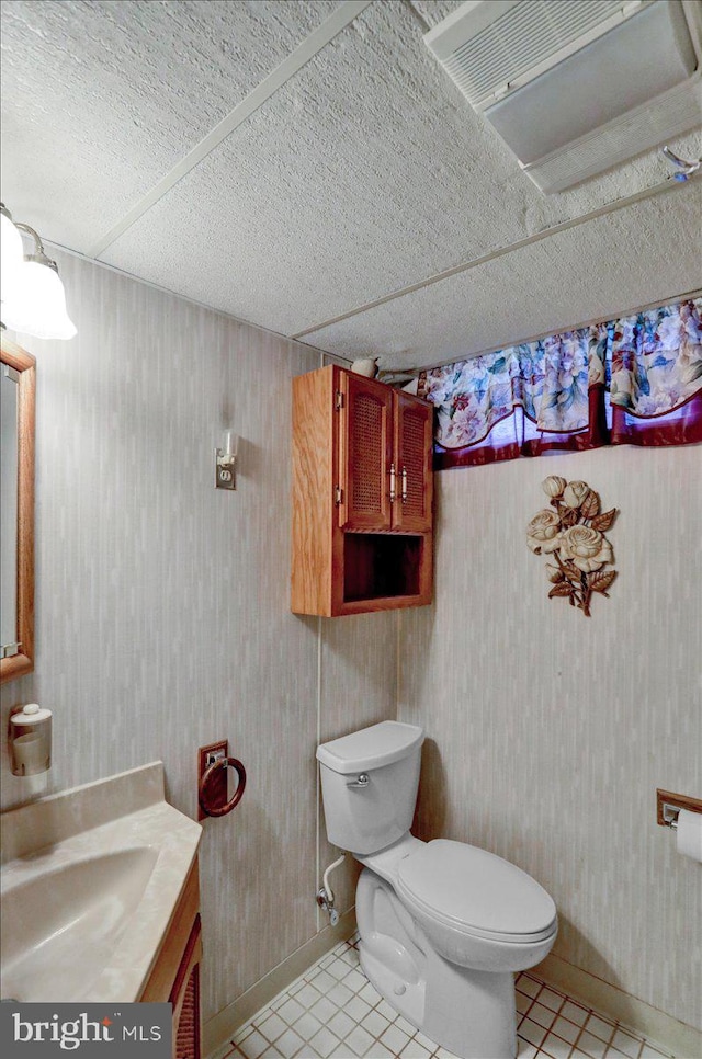 bathroom featuring vanity, tile patterned floors, and toilet