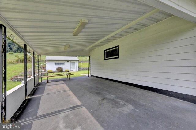 view of patio / terrace featuring a carport and an outbuilding