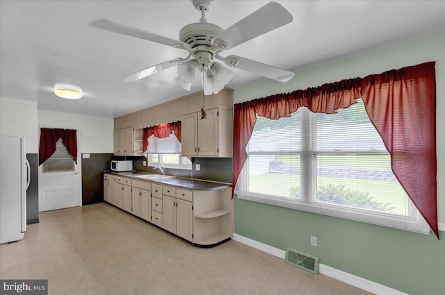 kitchen featuring tasteful backsplash, ceiling fan, plenty of natural light, and white appliances