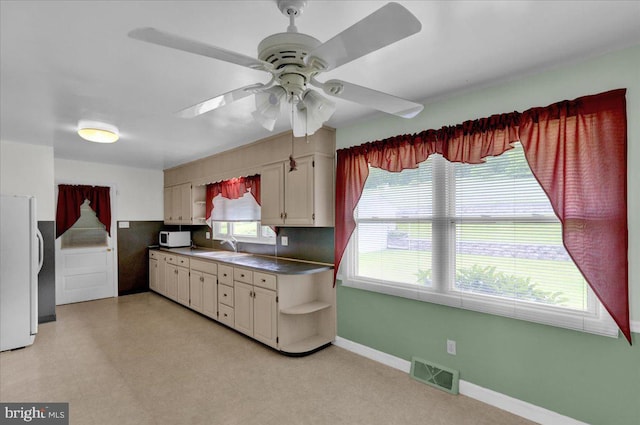 kitchen featuring ceiling fan, white appliances, sink, and cream cabinetry