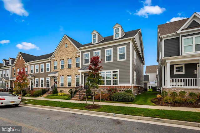 townhome / multi-family property featuring a front lawn