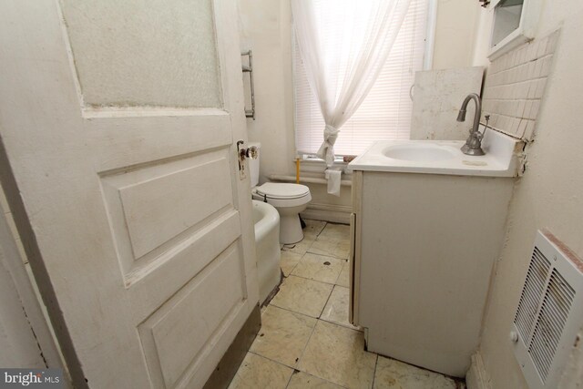 bathroom featuring backsplash, toilet, vanity, and tile patterned flooring