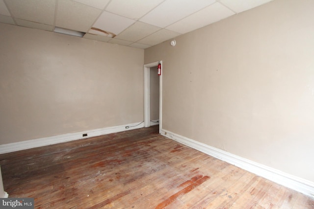 spare room featuring wood-type flooring and a paneled ceiling