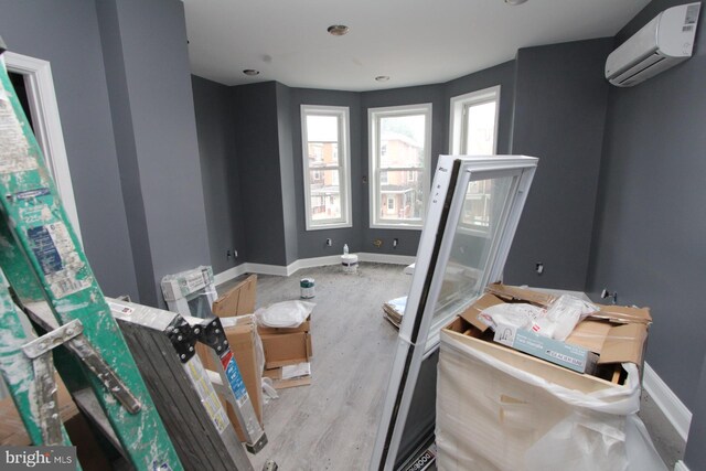 interior space with an AC wall unit and hardwood / wood-style flooring