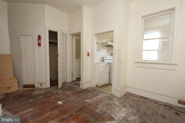 unfurnished bedroom featuring washer / dryer and hardwood / wood-style flooring