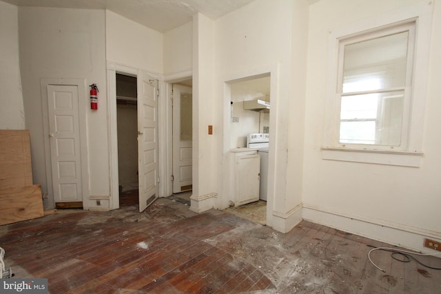 unfurnished bedroom with hardwood / wood-style flooring, washer / clothes dryer, and a closet