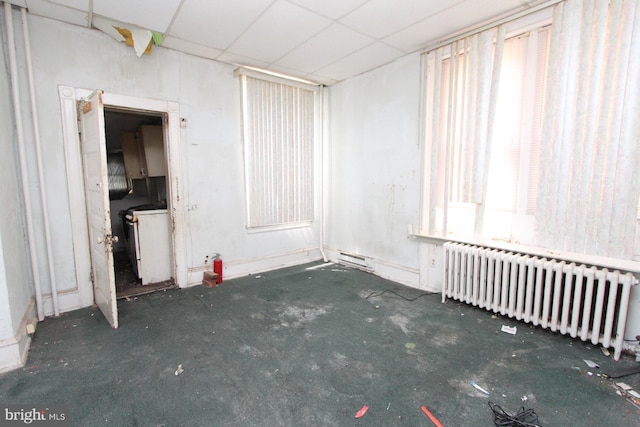 unfurnished room featuring a paneled ceiling and radiator