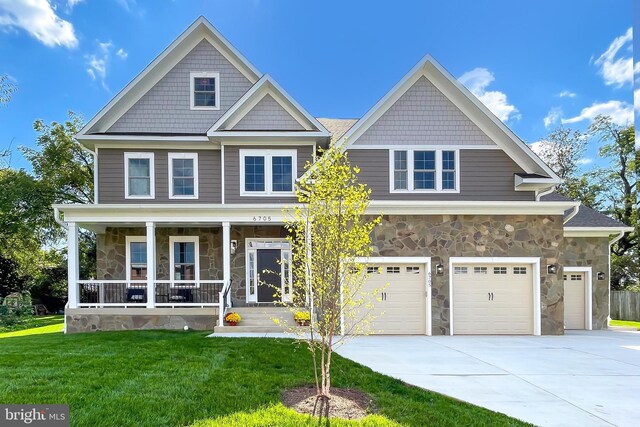 craftsman house featuring a garage, a porch, and a front yard