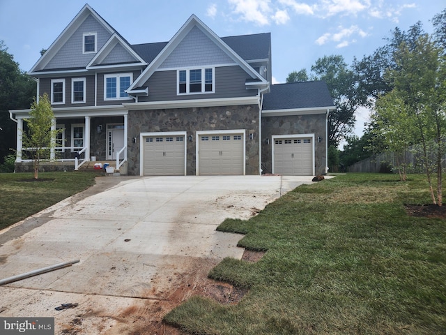 view of front of home featuring a porch, a front yard, and a garage