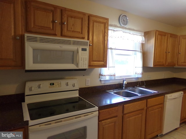 kitchen with light tile patterned flooring, sink, and white appliances