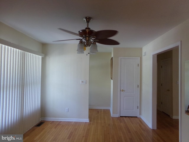 empty room with light wood-type flooring, ceiling fan, and a wealth of natural light