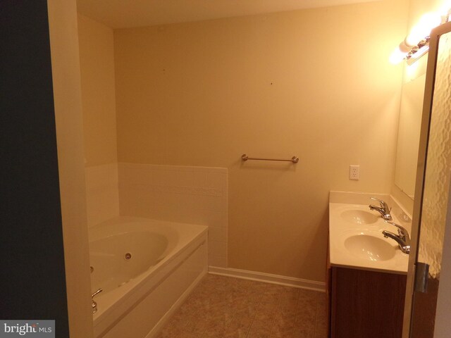 bathroom with tile patterned floors, a bathing tub, and dual bowl vanity