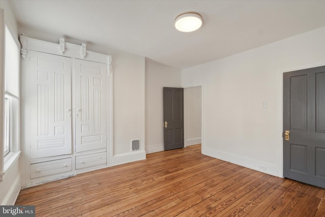 unfurnished bedroom with hardwood / wood-style flooring and a closet