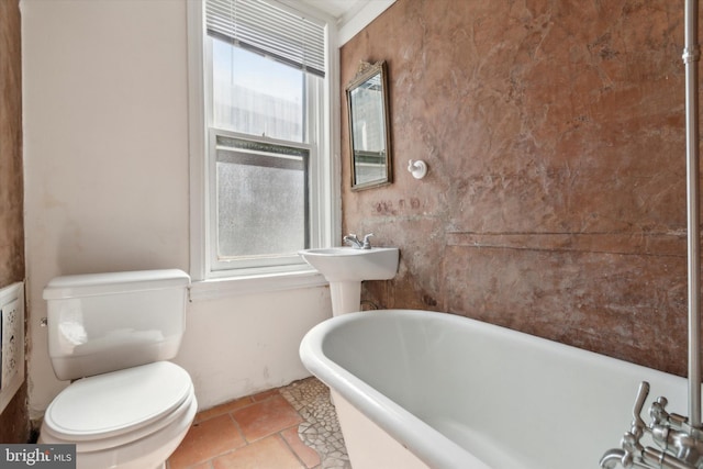 bathroom with a bathing tub, toilet, and tile patterned floors