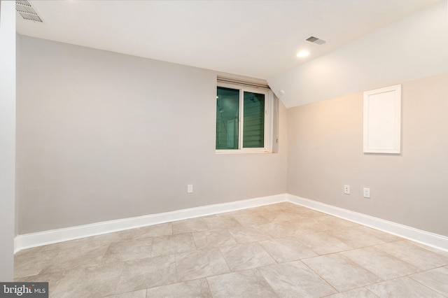 unfurnished room featuring vaulted ceiling