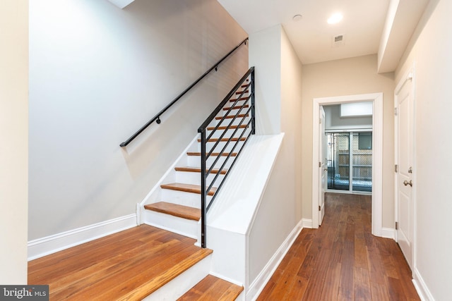 stairs featuring hardwood / wood-style floors