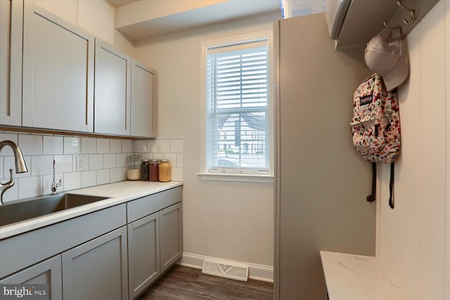 kitchen with gray cabinets, sink, backsplash, and dark hardwood / wood-style floors