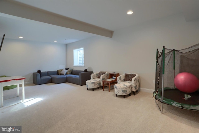 carpeted living room featuring beam ceiling