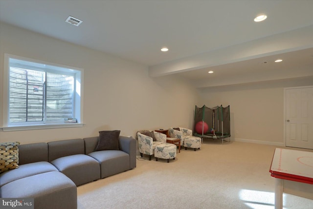 carpeted living room featuring beamed ceiling