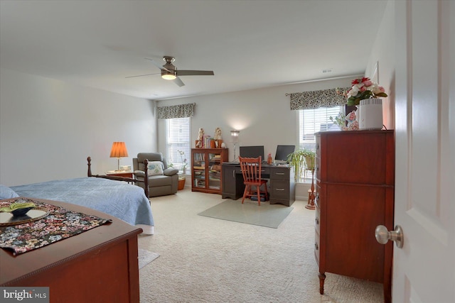 carpeted bedroom with multiple windows and ceiling fan