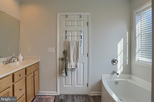 bathroom featuring vanity, hardwood / wood-style flooring, and a bathing tub