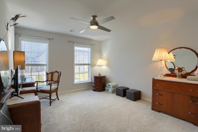 sitting room featuring ceiling fan, plenty of natural light, and light carpet