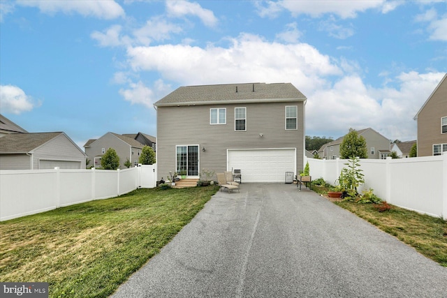 back of house featuring a yard and a garage