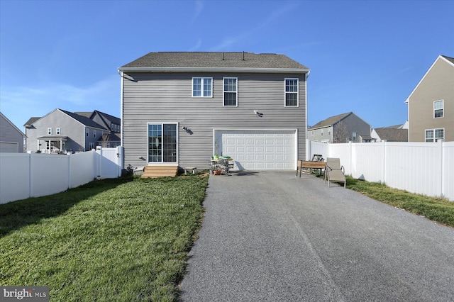 back of property featuring a garage and a lawn