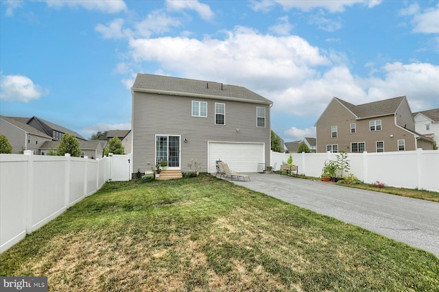 back of house featuring a garage and a yard