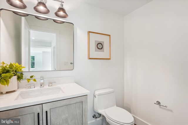 bathroom with vanity, toilet, and an inviting chandelier