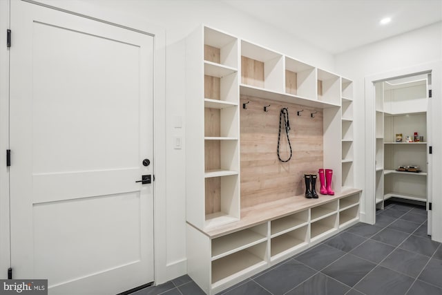 mudroom with dark tile patterned floors