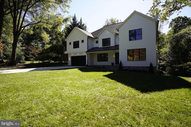 modern inspired farmhouse featuring a front lawn, covered porch, and a garage