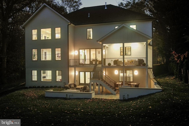 rear view of house featuring a lawn and a patio