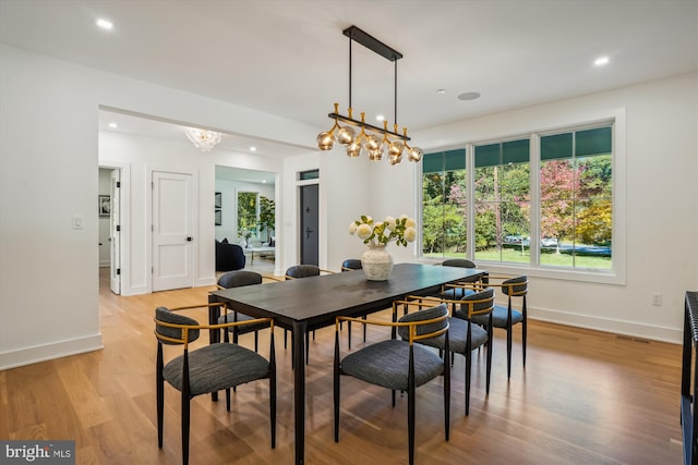 dining space featuring light hardwood / wood-style flooring and a notable chandelier