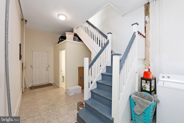 stairs with tile patterned floors and washer / dryer