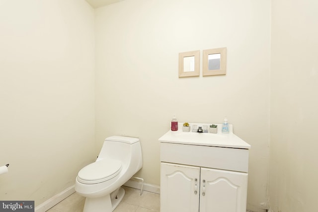 bathroom with toilet, vanity, and tile patterned floors