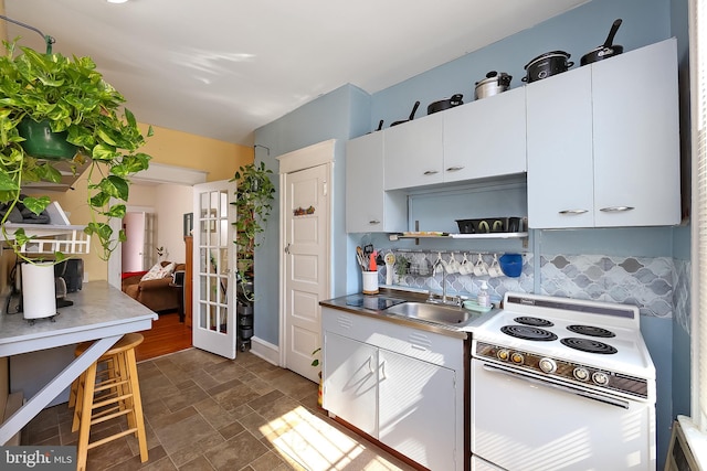 kitchen featuring decorative backsplash, white cabinetry, dark hardwood / wood-style floors, sink, and white range with electric cooktop