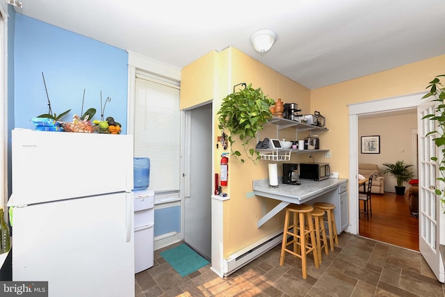 kitchen featuring a baseboard radiator, dark hardwood / wood-style flooring, and white refrigerator