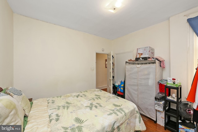 bedroom with dark hardwood / wood-style floors